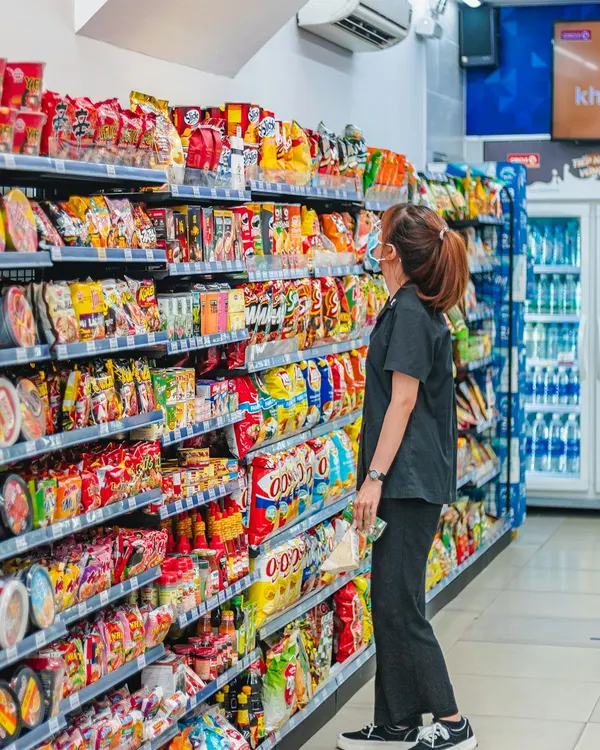 Shopkeeper serving a customer at a convenience store counter