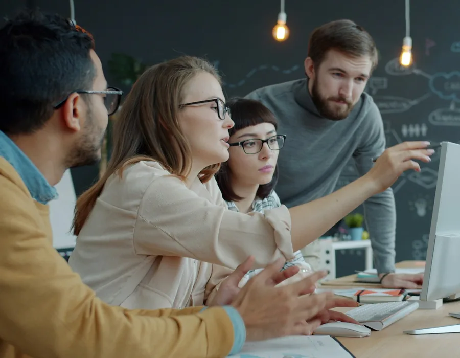 A team working together around a computer in an office