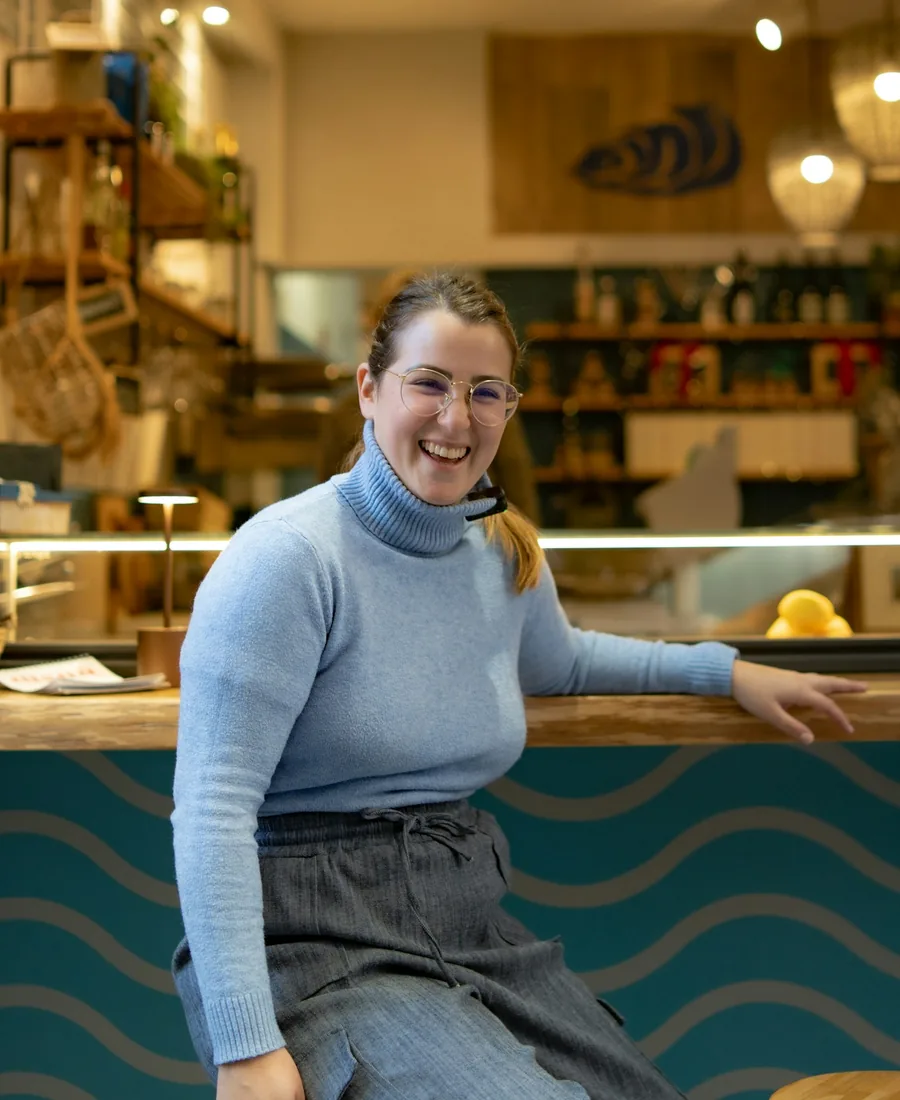 Smiling café owner at her counter